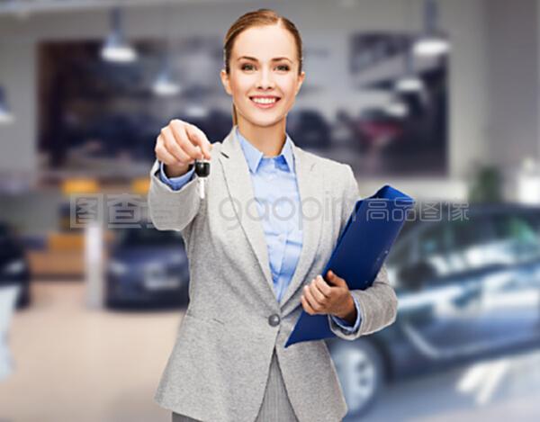 汽車業(yè)務(wù),汽車銷售,手勢(shì)和人的概念-快樂的女商人或售貨員與文件夾給車鑰匙在汽車展示背景
